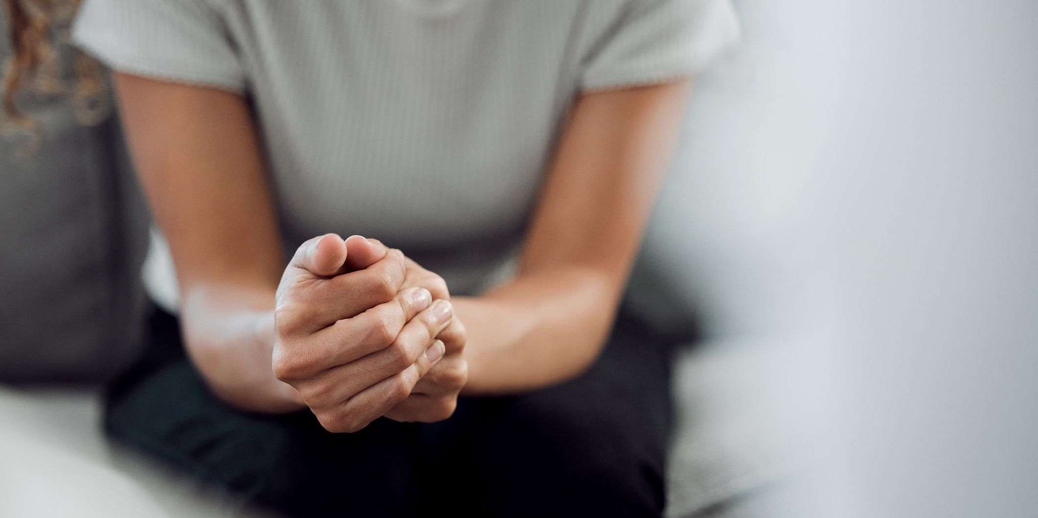 woman sitting with hands clenched