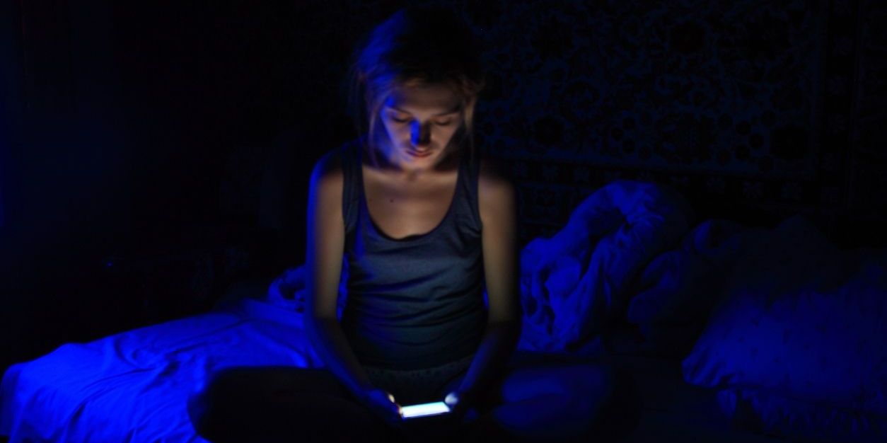 woman getting blue light on phone at night